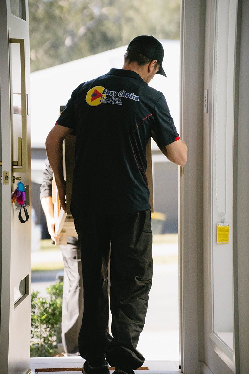 Delivery Person Carrying Box Into A House — Easy Choice Removals and General Freight In Port Macquarie, NSW