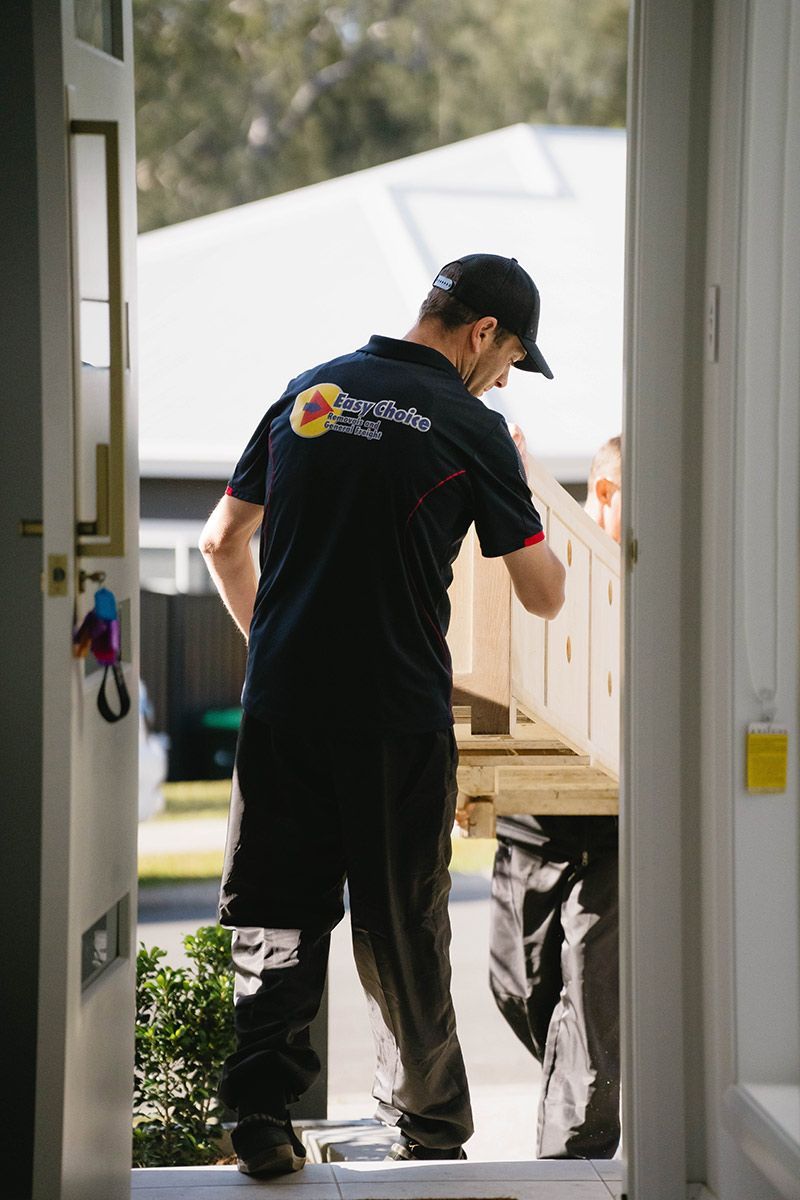 Movers Carry Wooden Furniture Through a Doorway — Easy Choice Removals and General Freight In Port Macquarie, NSW