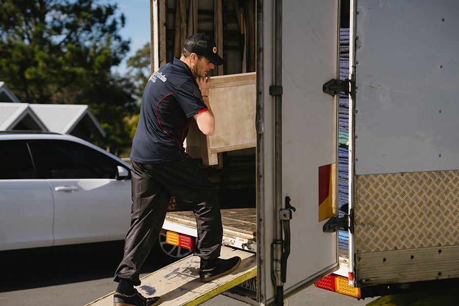 Man Loading a Large Box Into a Truck — Easy Choice Removals and General Freight in Taree, NSW