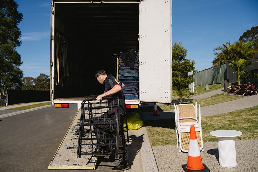 Moving Worker Loading Black Metal Chairs — Easy Choice Removals and General Freight In Canberra, ACT