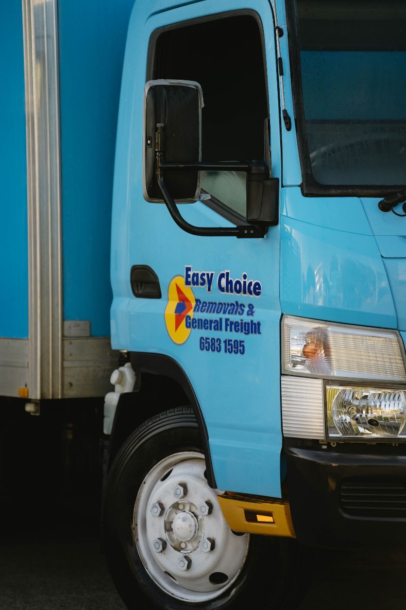 A White Moving Truck is Parked on the Side of the Road — Easy Choice Removals and General Freight In Port Macquarie, NSW