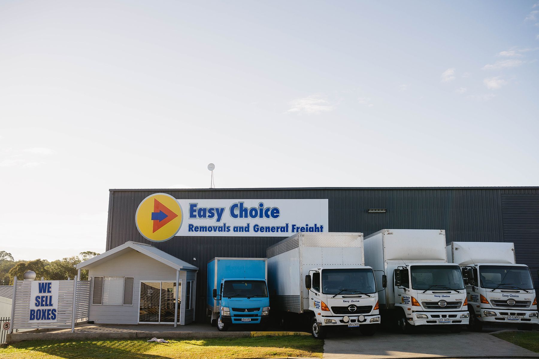 Blue Delivery Truck Parked Amongst Storage Containers, Sunny Day — Easy Choice Removals and General Freight In Port Macquarie, NSW