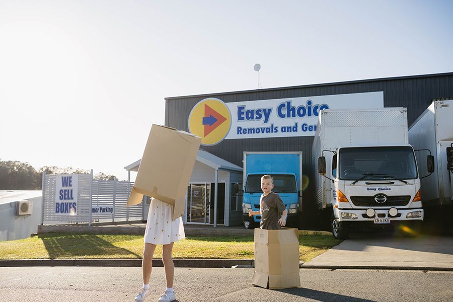 Children Playing With Boxes in Front of a Moving Company — Easy Choice Removals and General Freight In Gosford, NSW