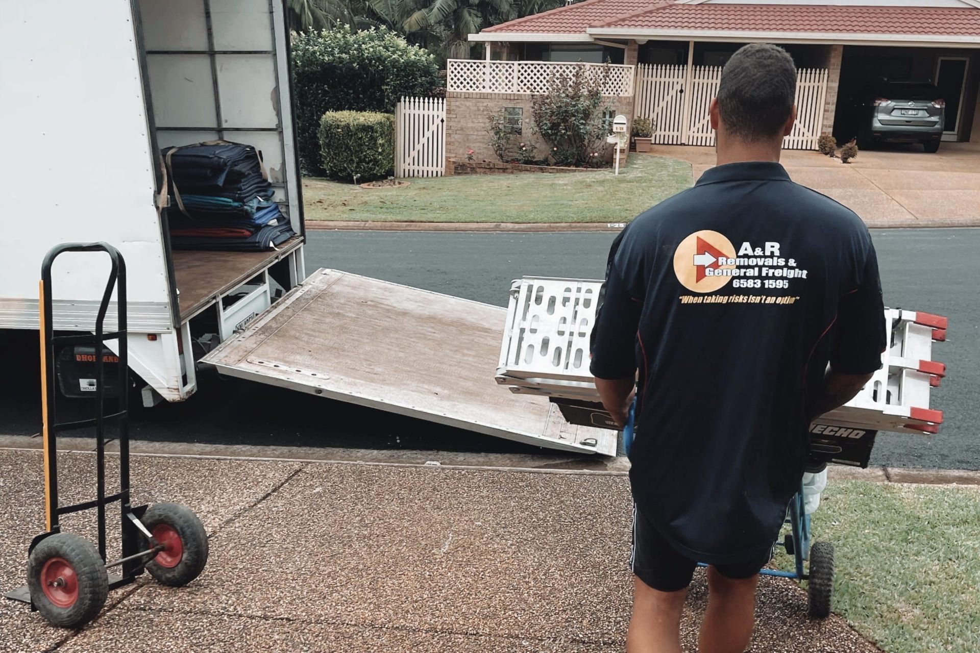 A Man Wearing a Black Shirt With the Letter F on It — Easy Choice Removals and General Freight In Port Macquarie, NSW