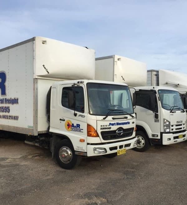 A Row of White Trucks With the Letter R on the Side — Easy Choice Removals and General Freight In Port Macquarie, NSW