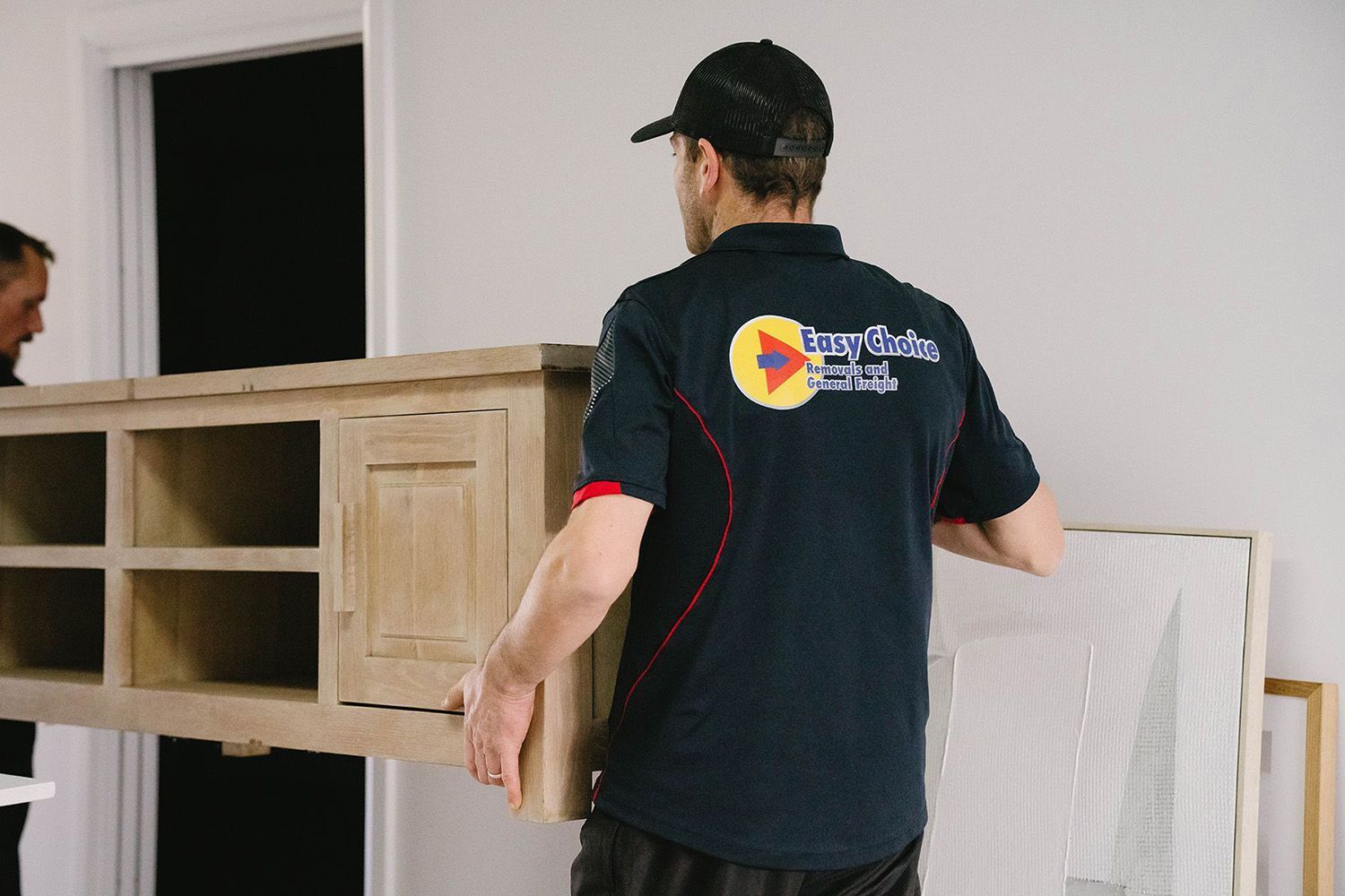 Removalists Carrying A Wooden Cabinet