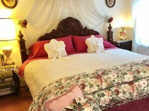 A bed with a floral comforter and pillows in a bedroom.