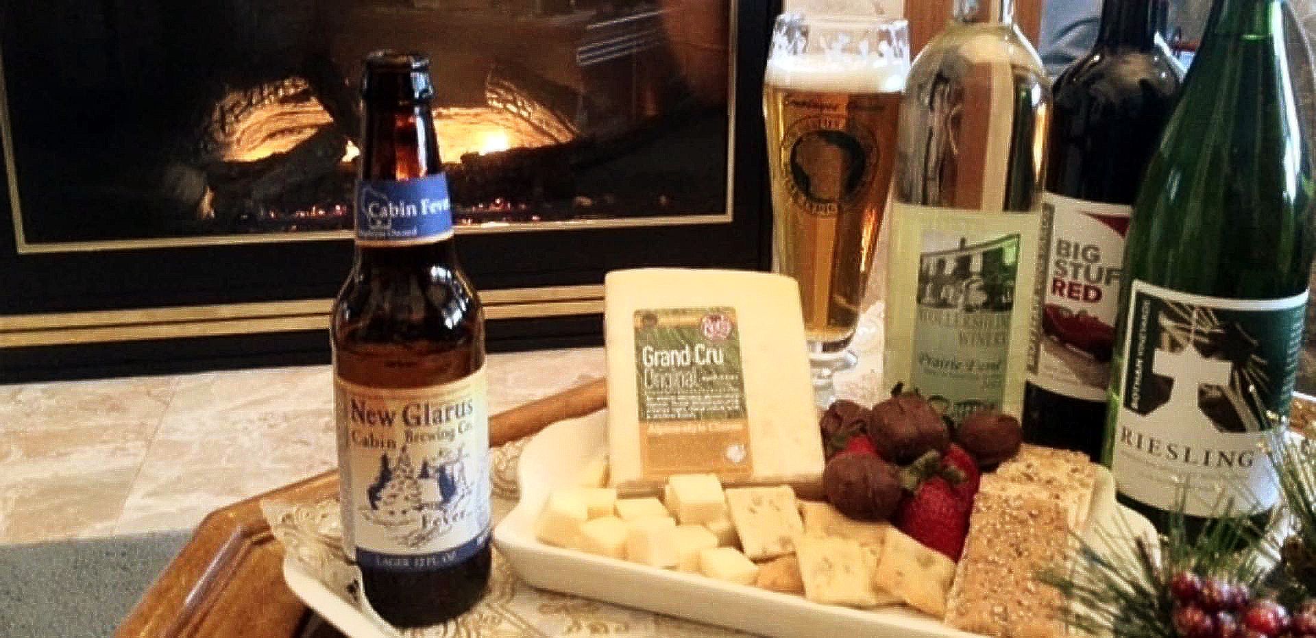 A bottle of beer sits on a table next to a plate of cheese and crackers