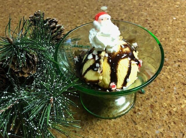 A bowl of ice cream with a santa claus on top.