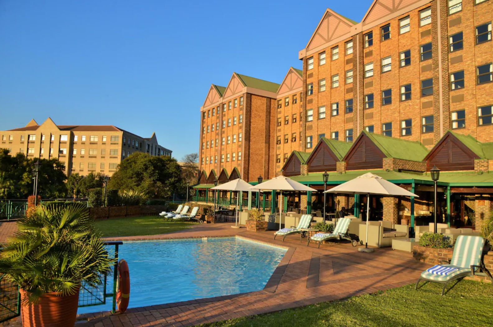 A large brick building with a swimming pool in front of it.