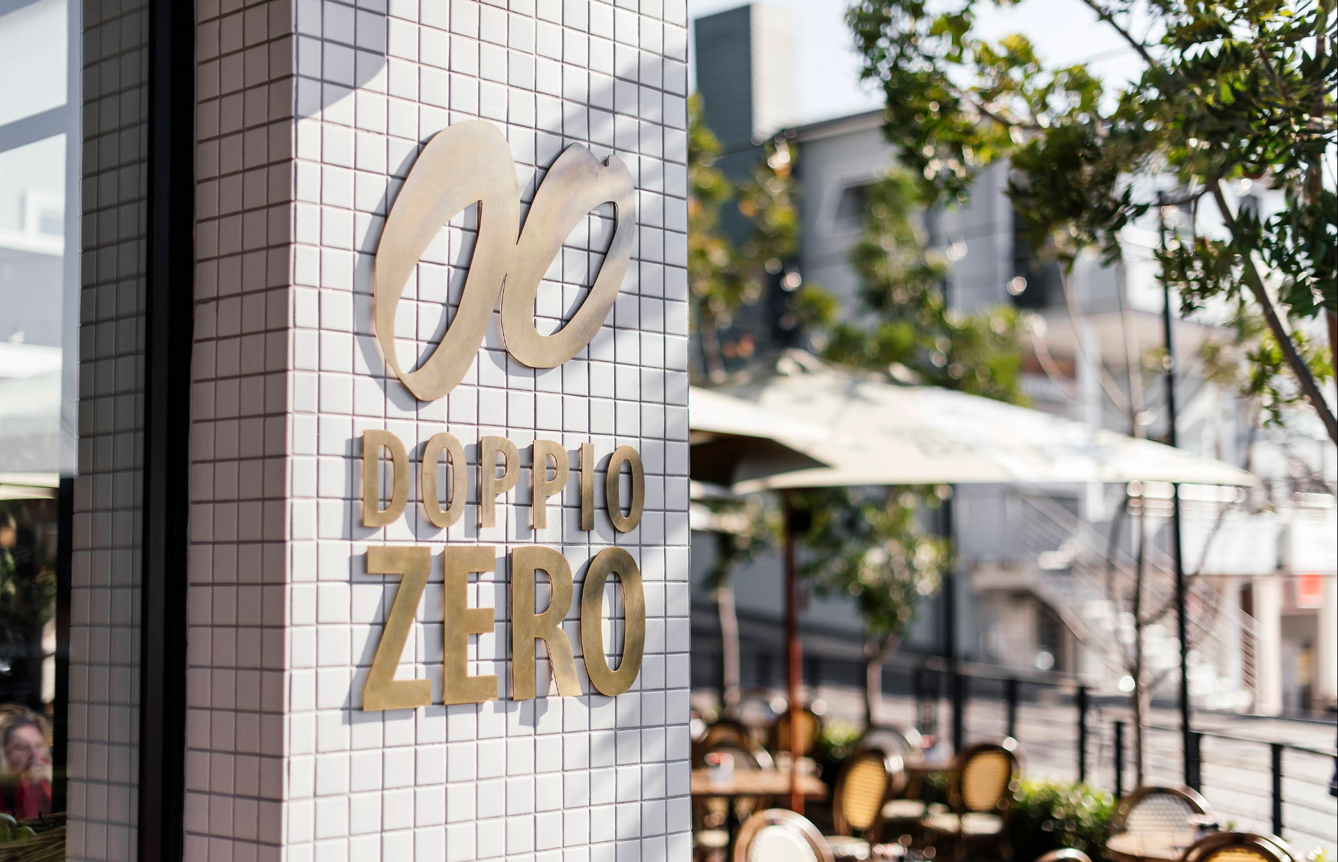 A sign for doppio zero is on the side of a building.