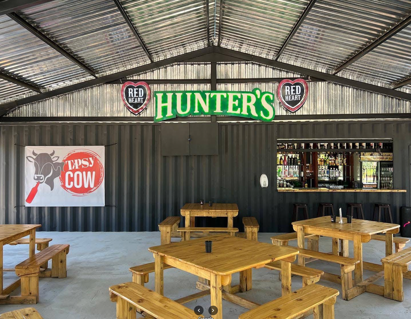 A restaurant with wooden tables and benches and a sign that says hunter 's