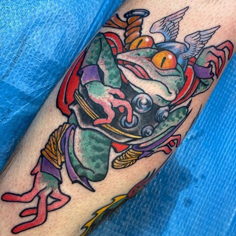 Colorful dragon tattoo on a forearm, with green, red, and blue details.