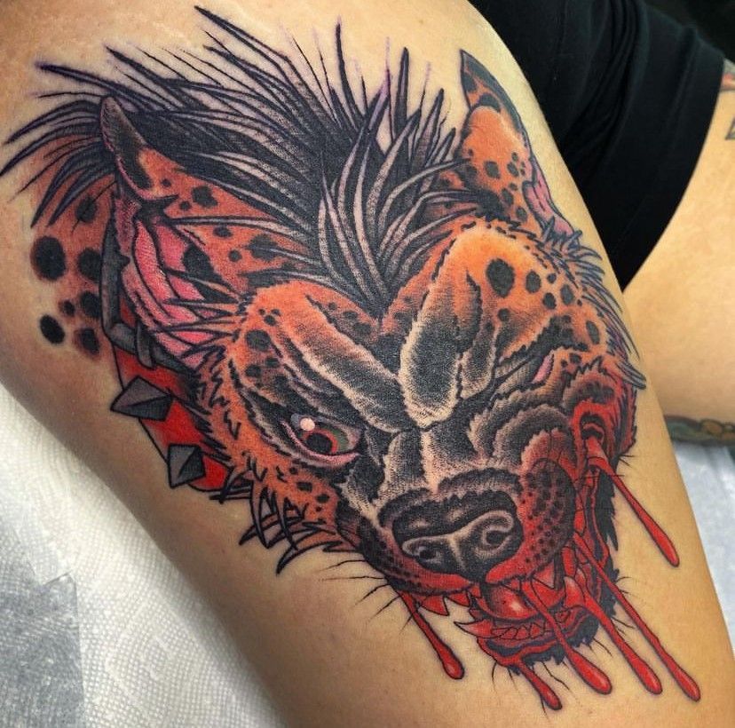 Black-and-red wolf tattoo with a red eye and dripping ink on skin
