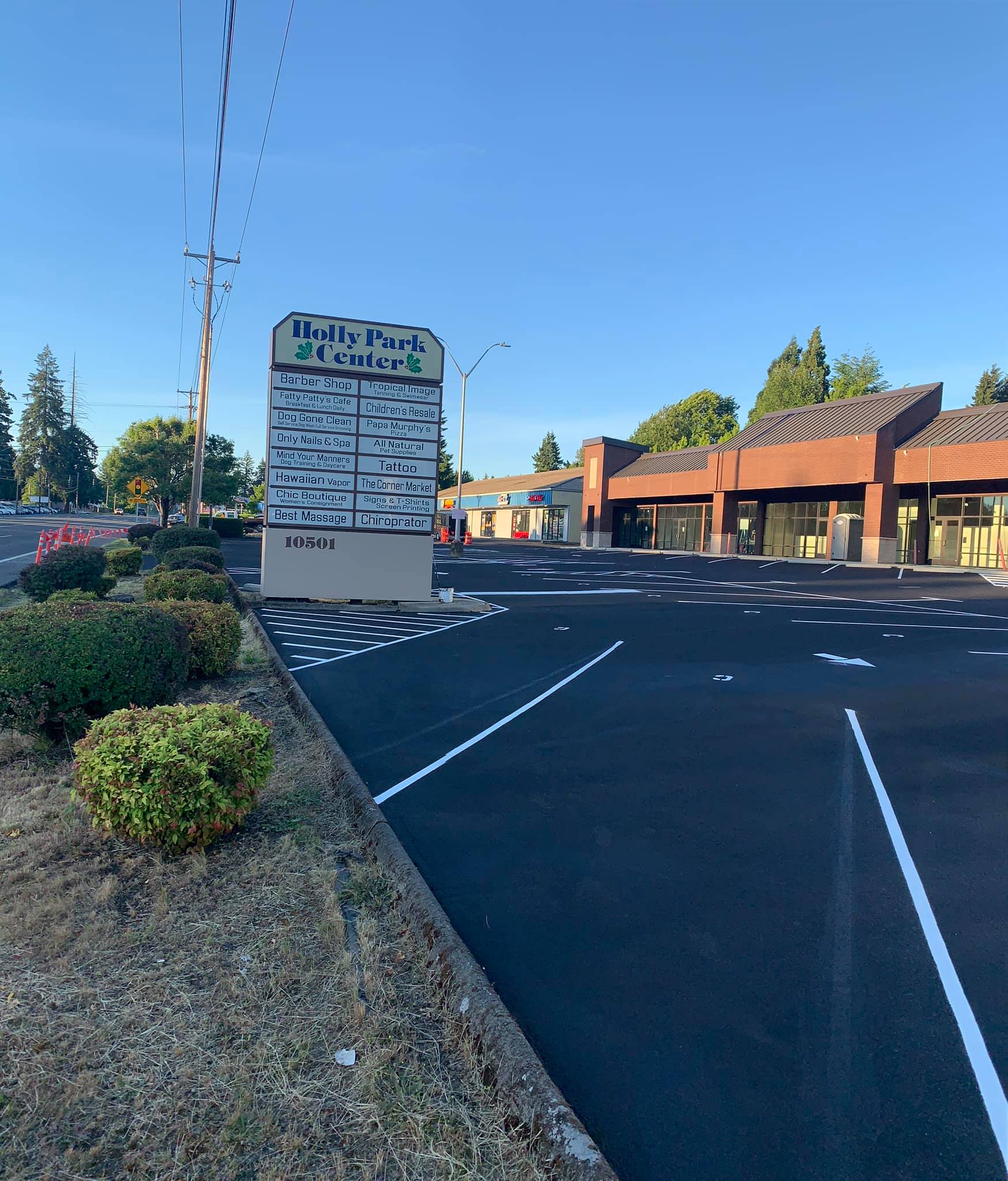A parking lot in front of a building with a sign that says that 's a lot