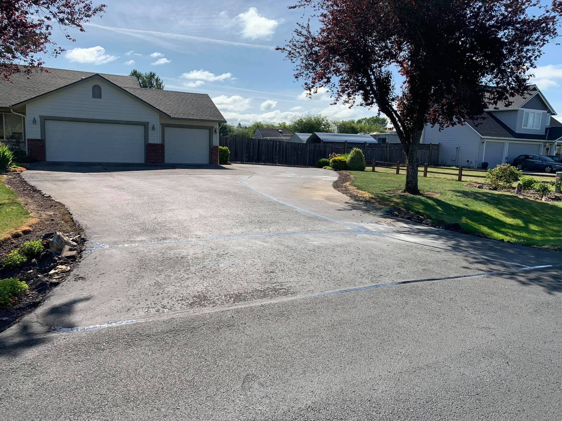 A driveway leading to a house with two garage doors