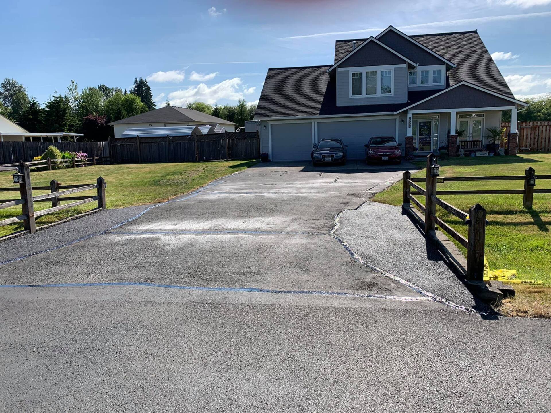 A house with a driveway and a fence in front of it