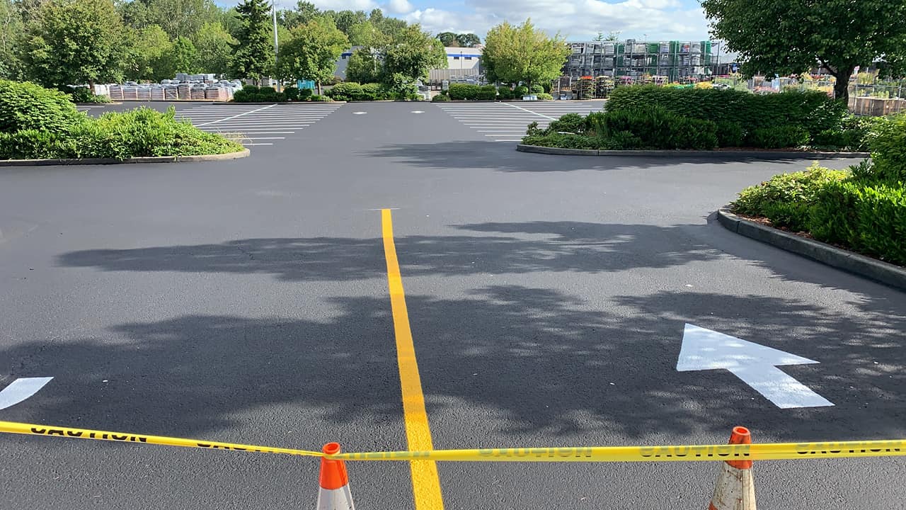 A parking lot with a yellow line and an arrow painted on it.