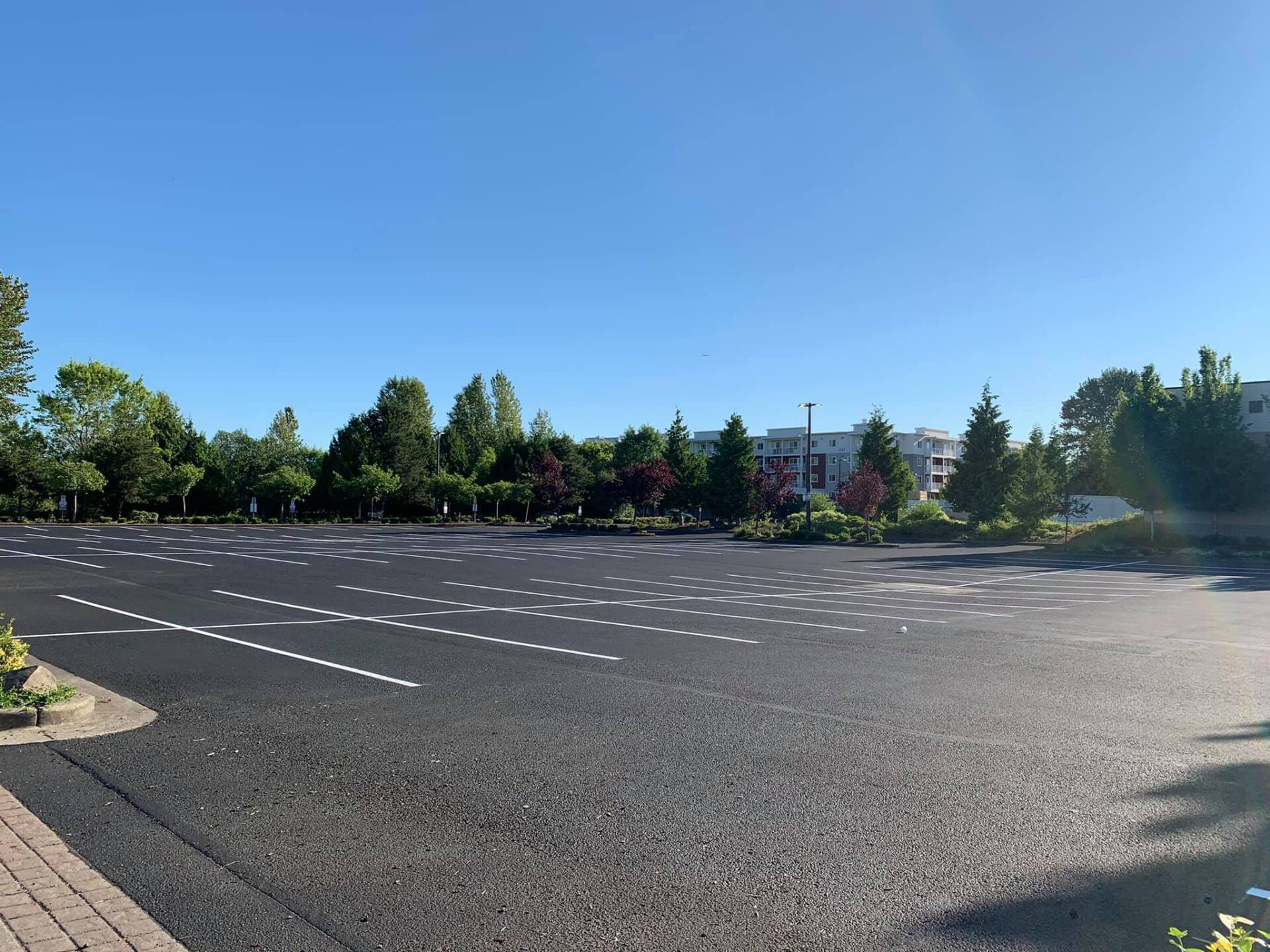 An empty parking lot with a building in the background