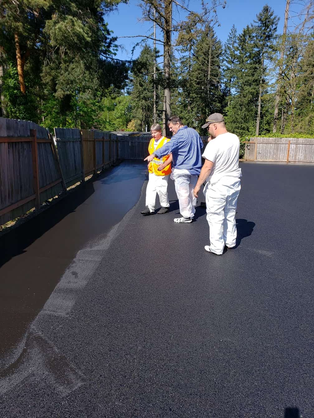 A group of men are standing on the side of a road.