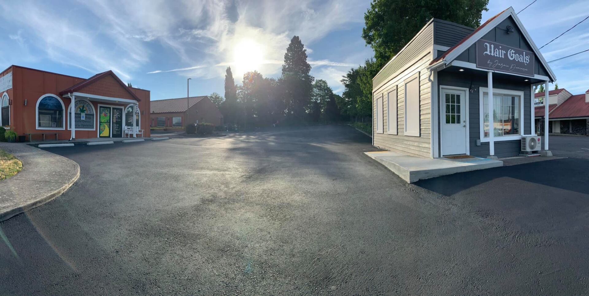 There are two buildings in the middle of a parking lot.