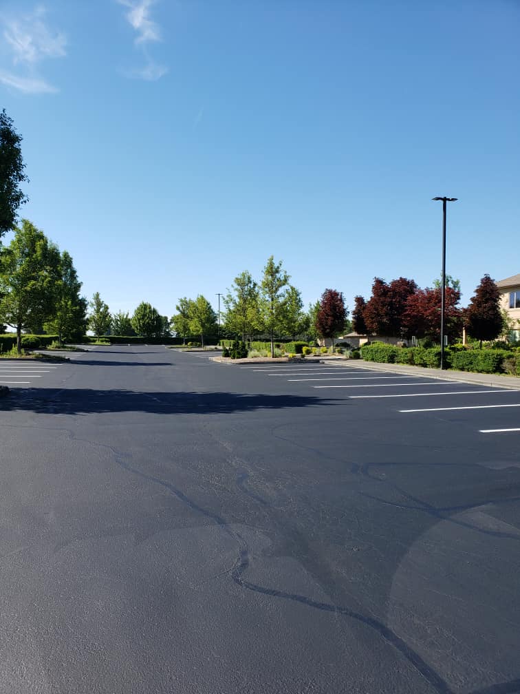 A parking lot with trees and a building in the background