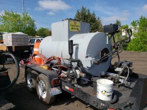 A trailer with a large tank on it is parked in a parking lot.