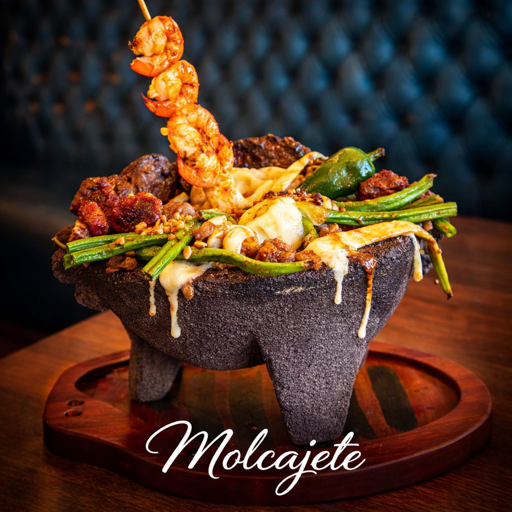 An orange plate featuring steak, fried plantains, red onions, avocado, salsa, rice, and beans with melted cheese.