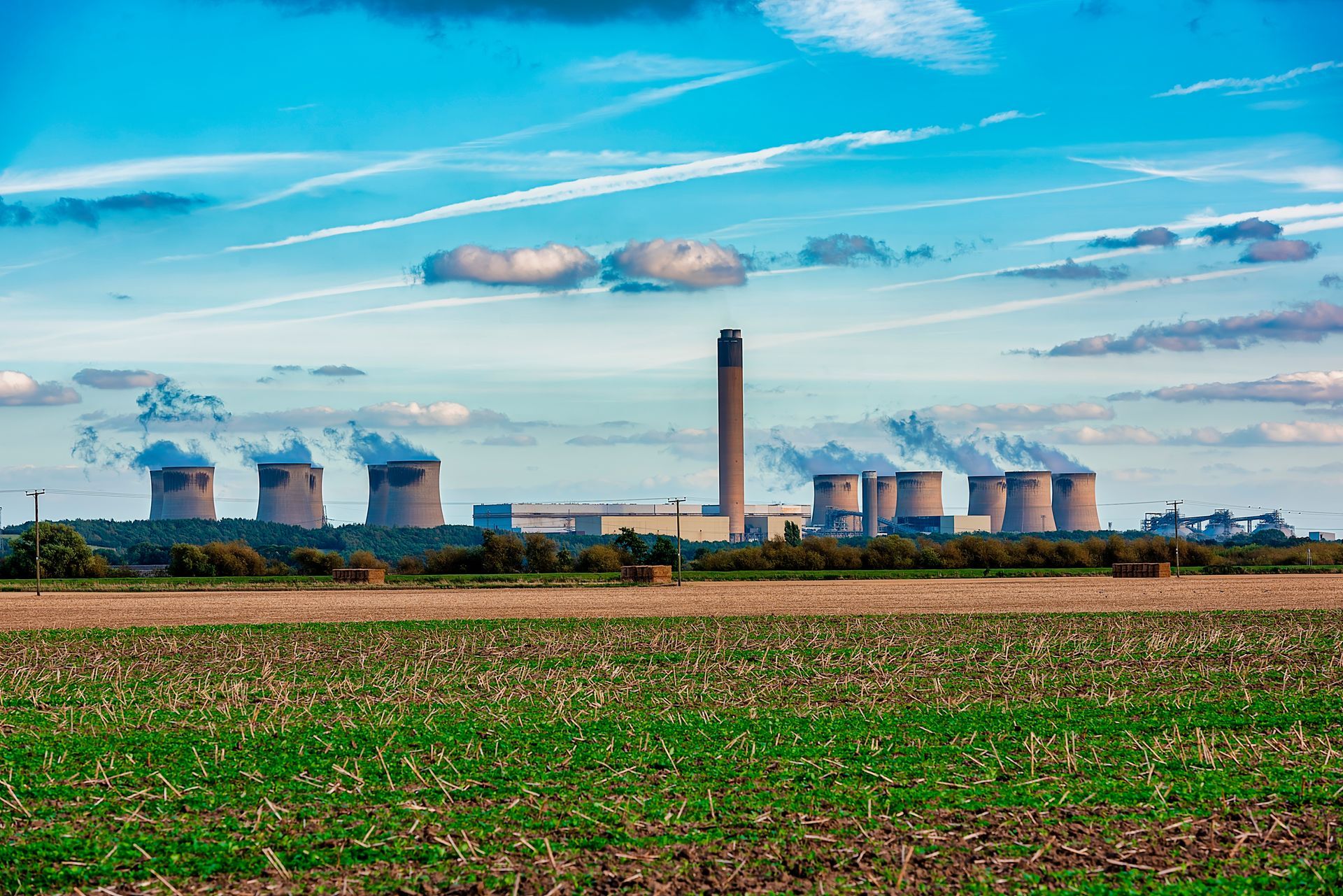 There is a power plant in the middle of a field.