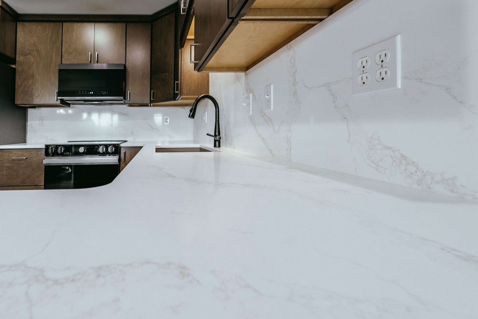 Spacious view of quartz coiuntertops and matching backsplash