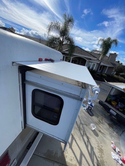 A white trailer with a canopy on top of it