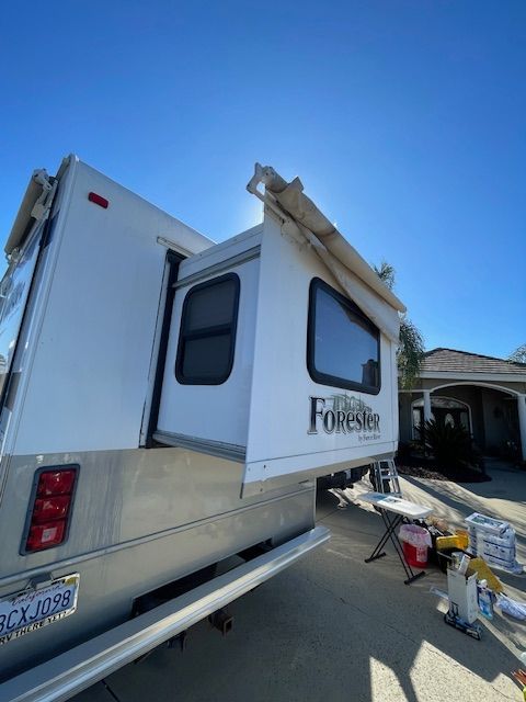 A white forester trailer is parked in a driveway