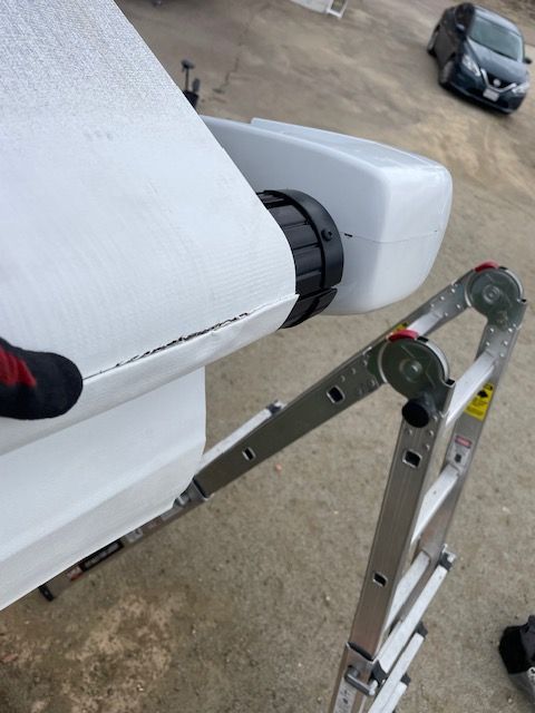 A person standing on a ladder holding a piece of paper