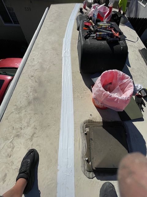 A person standing on a roof with a pink trash bag on it