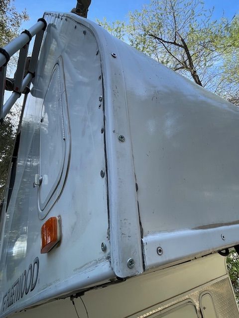 A white canopy is attached to the side of a truck.