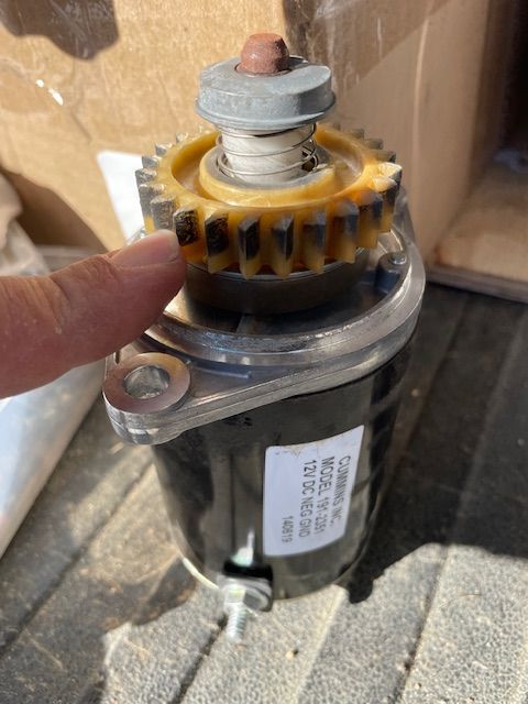 A person is pointing at a gear on a motor