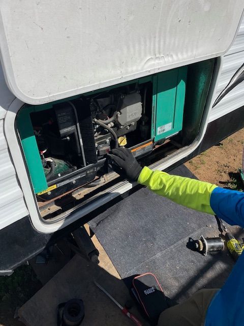A person is working on a generator in the back of a trailer
