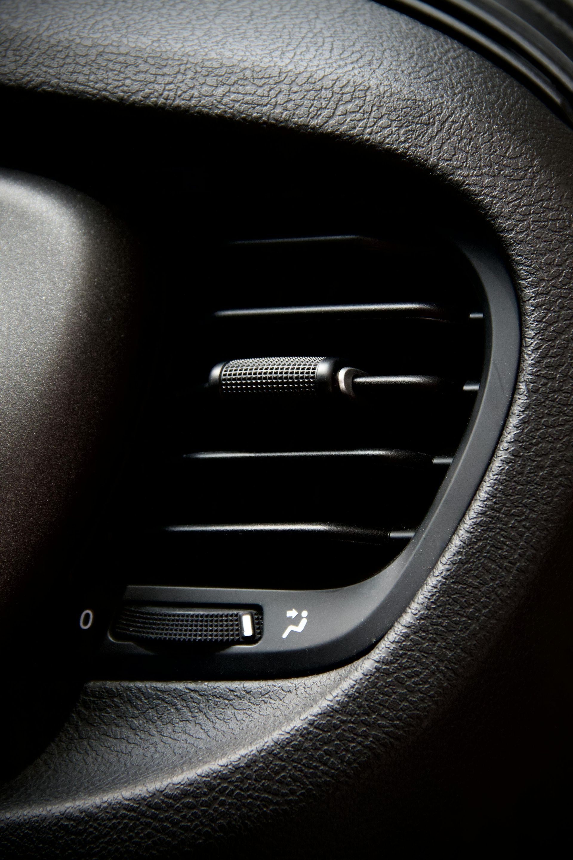 Car air vent in black textured plastic.
