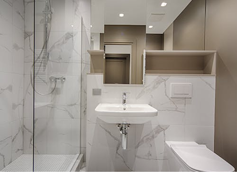 Modern bathroom with wooden vanity, black sinks/fixtures, toilet, and light stone tile walls.