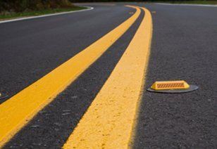 A yellow line is painted on the side of a road.