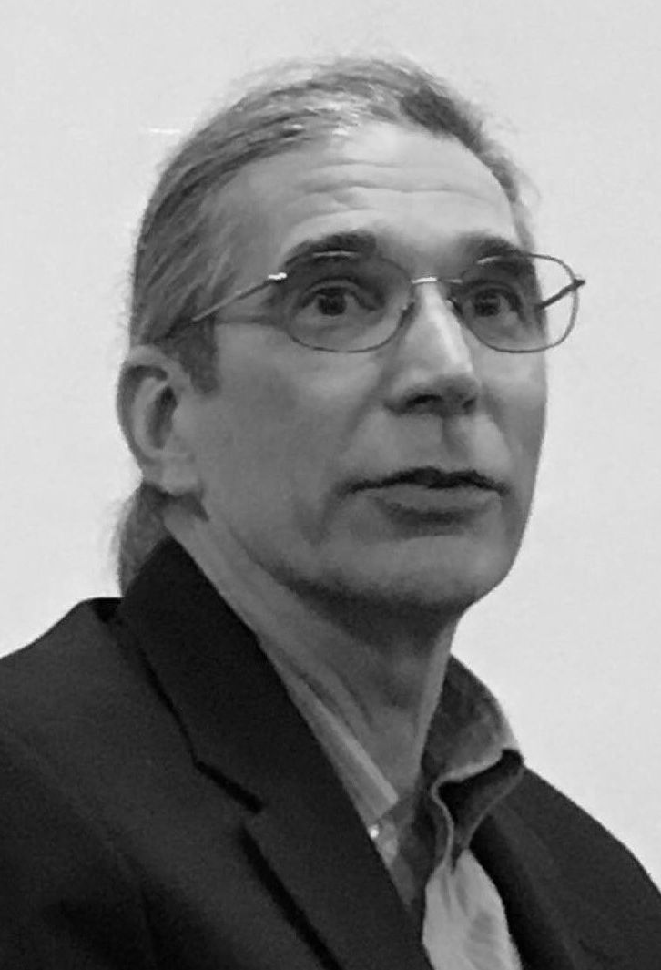 a black and white photo of DAVID SCHERER wearing glasses and a suit .