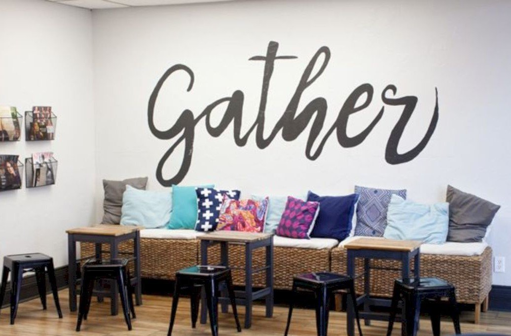 a room with a couch and chairs and the word gather on the wall