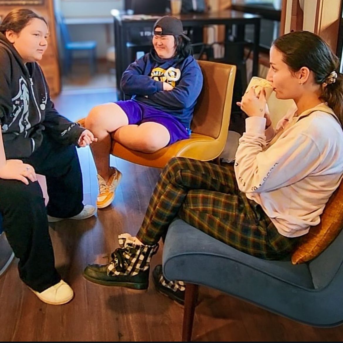 Three people sit at Nest Coffeehouse connecting
