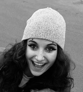 AJ Schott (she/her) smiling in a black and white photo .