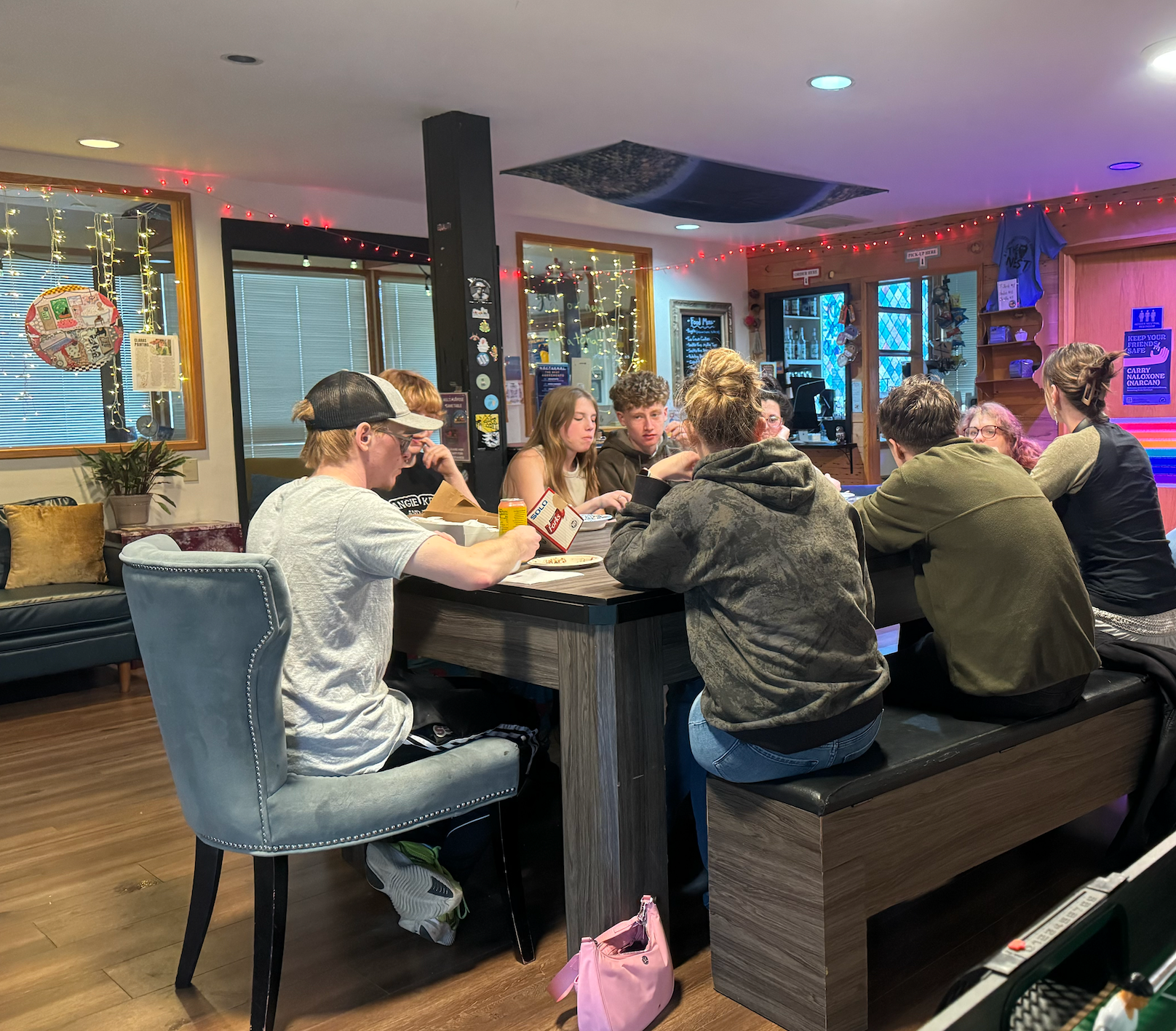 a group of people are sitting at a table with laptops .