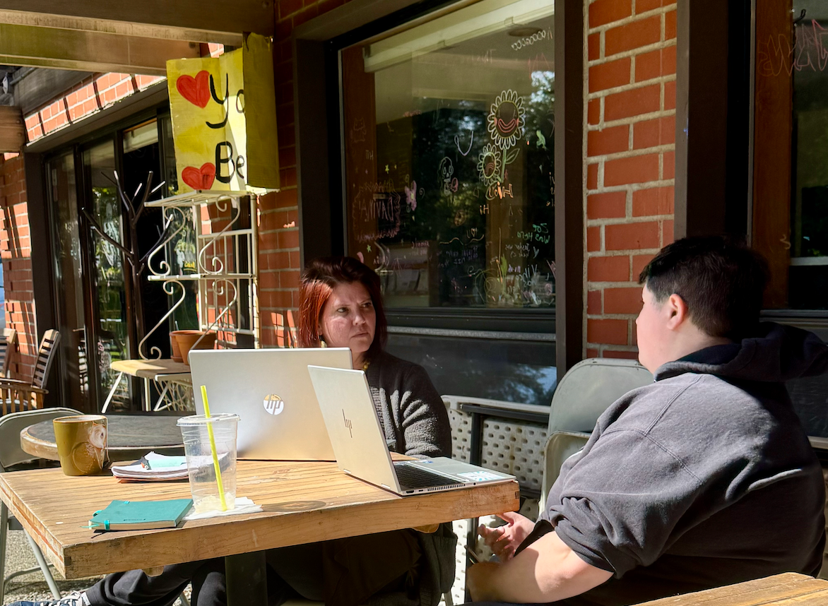 a woman is sitting at a table talking to another woman .