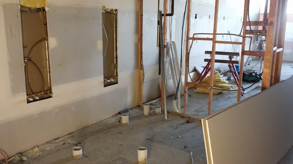 A restaurant is being built with a brick wall and a checkered floor.