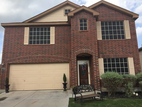 A large brick house with a bench in front of it