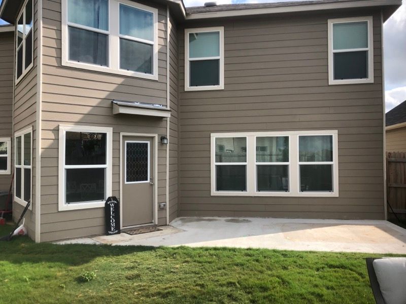 A house with a lot of windows and a patio in front of it