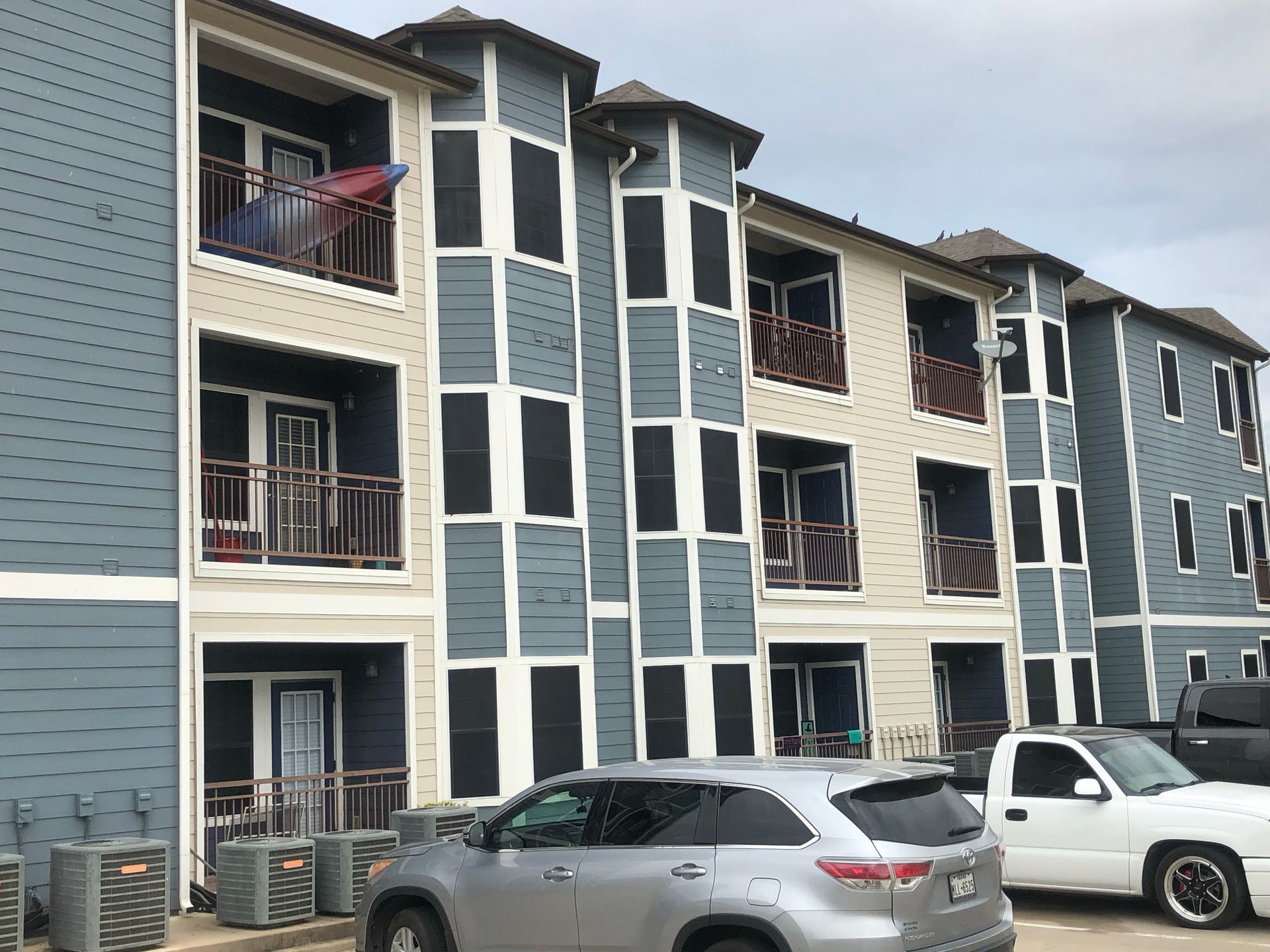 A building with a lot of windows and cars parked in front of it.